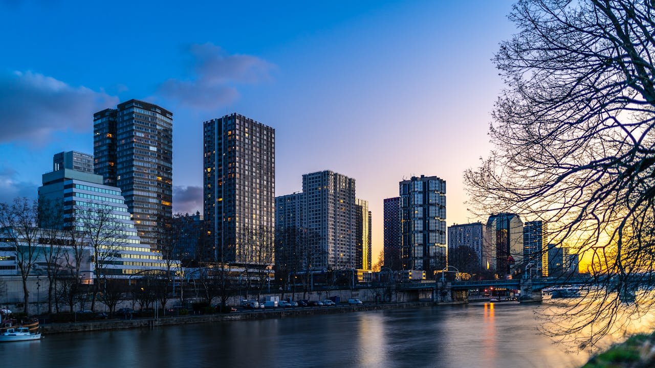 Stunning Paris skyline featuring modern skyscrapers by the river during sunset.